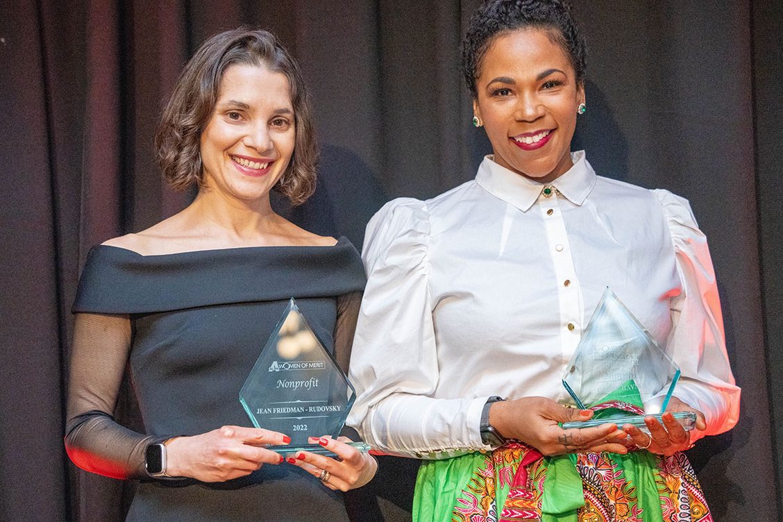 Cassie and Jean smile and pose after receiving their Nonprofit Women of Merit award from Al Dia News.