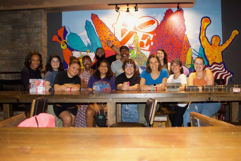 Some of the Resolve Philly staff posed in front of an indoor mural